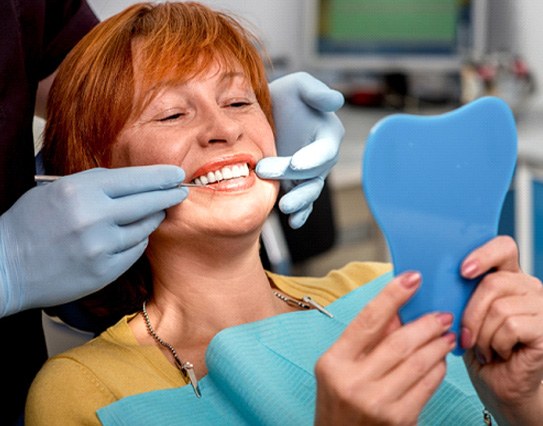 A woman admiring her new dentures