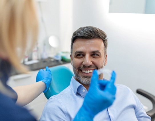Dentist showing someone a clear aligner