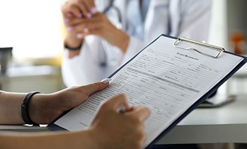 a patient filling out forms on a clipboard
