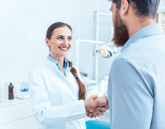 Dentist shaking hands with her patient