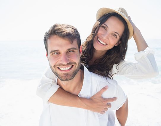 young couple smiling on the beach