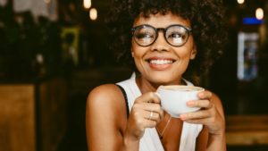 woman drinking coffee after healing from a tooth extraction 