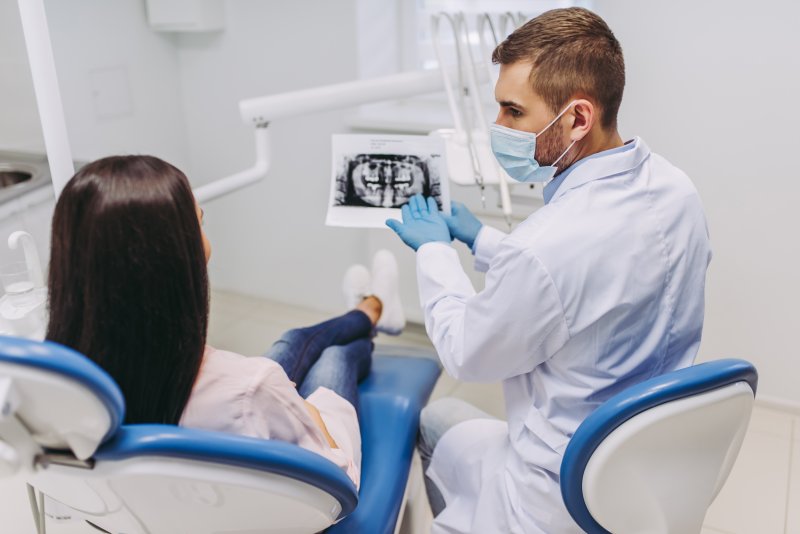 Implant dentist discussing X-ray with patient