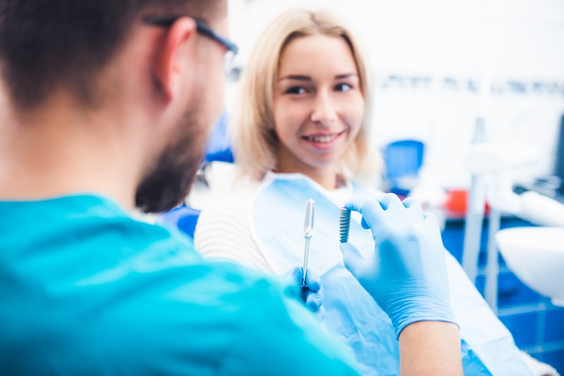 hygienist showing model to dental implant candidate in Little Rock