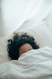 Sleeping woman with blanket over face