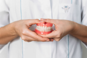 a closeup of dentures in someone’s hands