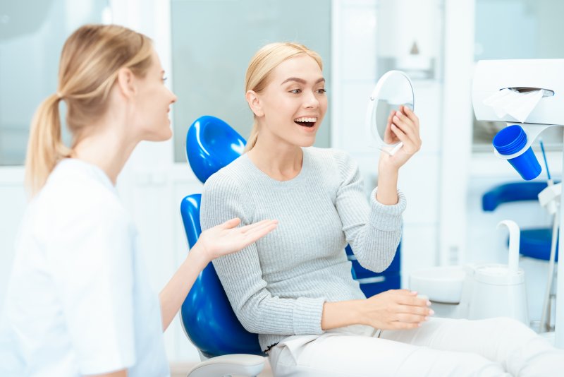 A woman admiring the results of cosmetic dentistry