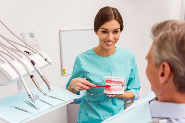 person smiling and holding dentures 