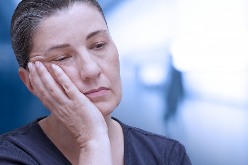 Patient holding their cheek due to dental emergencies