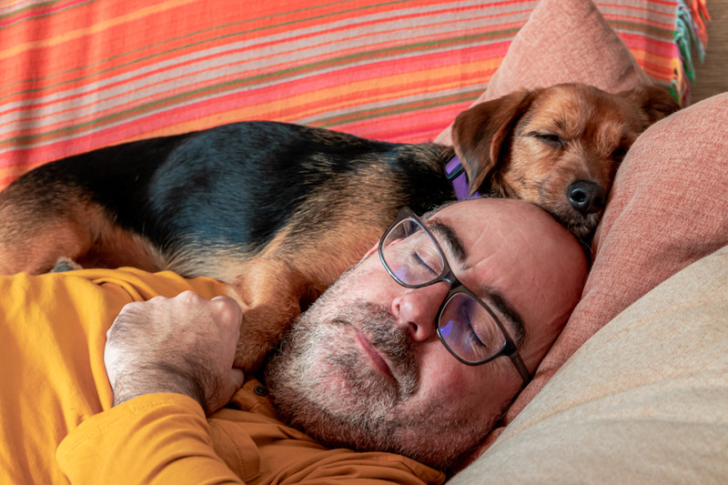 Patient with sleep apnea napping with their dog